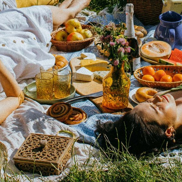 Rituale zur Sommersonnenwende – Frauen liegen auf Wiese beim Picknick