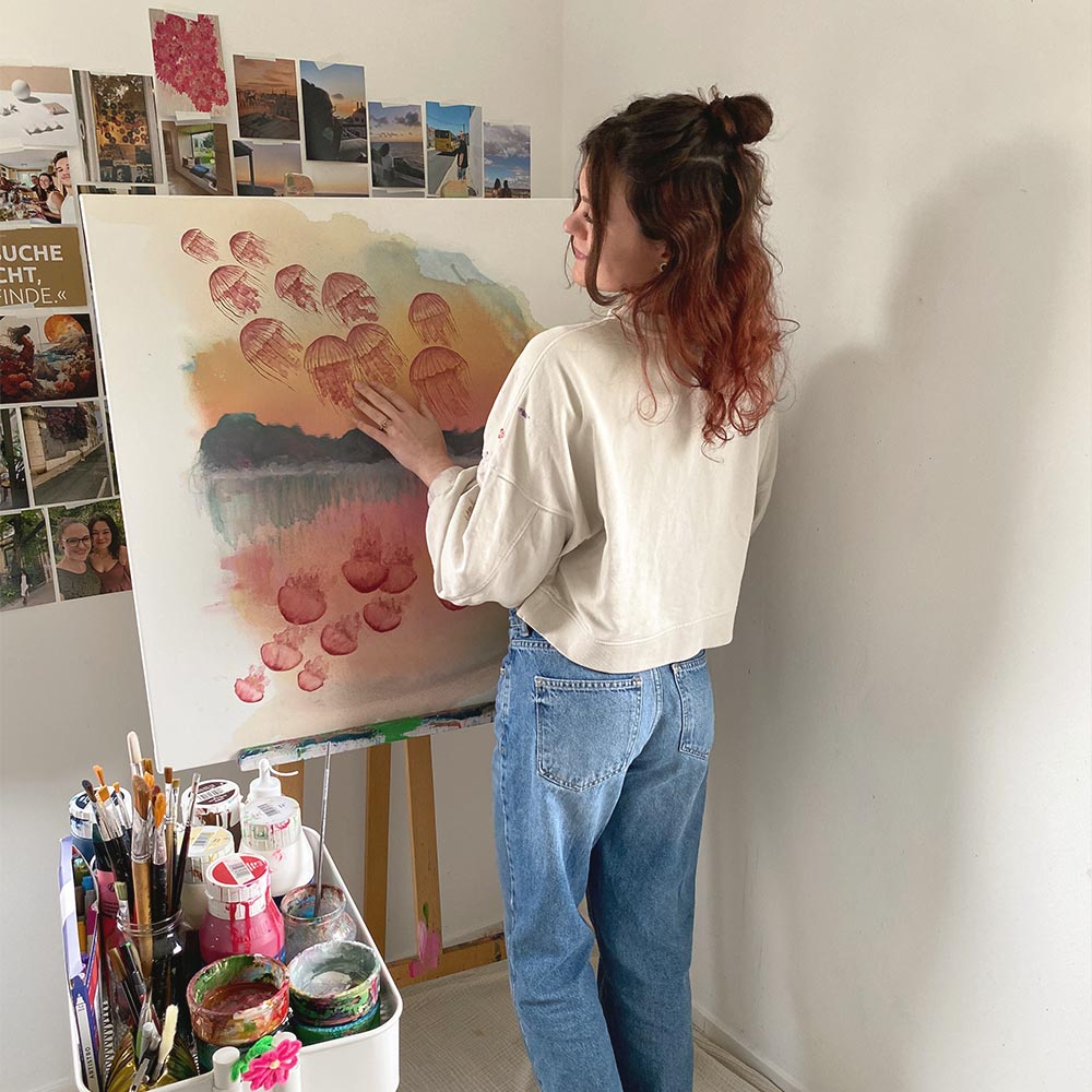 Künstlerin Noenya vor abstrakter Kunst: Quallen im Sonnenaufgang