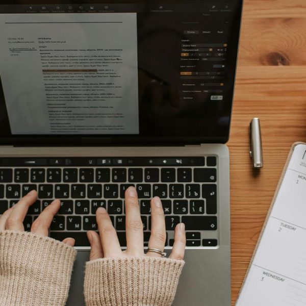 Herbst Ziele erreichen: Frauenhände am Laptop, daneben Kalender, Smartphone und Herbstdeko