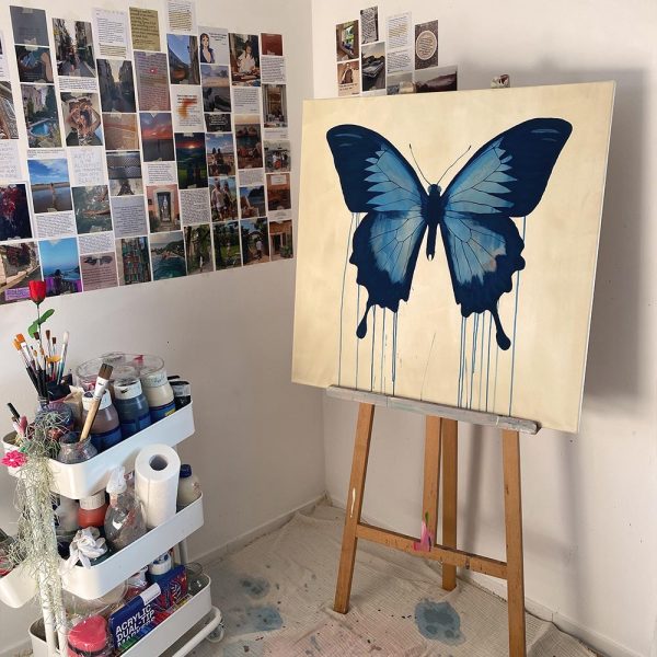 Blauer Schmetterling auf beiger Leinwand